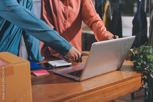 Startup SME small business entrepreneur of freelance Asian woman wearing apron using laptop and box to receive and review orders online to prepare to pack sell to customers, online sme business ideas.