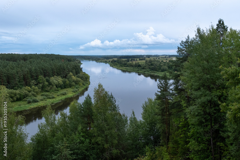 Obraz premium a river with clouds and a forest
