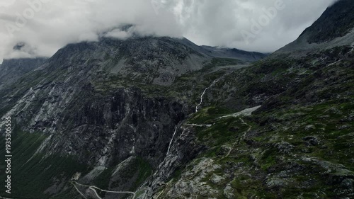Drone captures the 280 meter Trollfossen waterfall on the Tverelva river, Storgrovfjellet mountain shrouded in clouds, and Isterdalen valley in Møre og Romsdal county, Norway.
