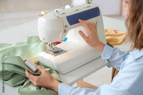 Young female tailor using s...