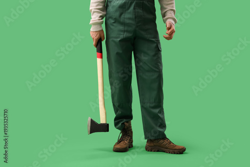Male worker with ax on gree...