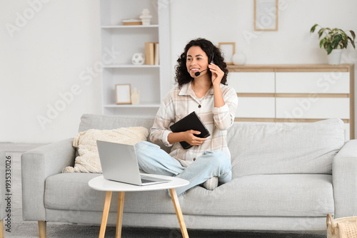 Female African-American business consultant working online on sofa at home