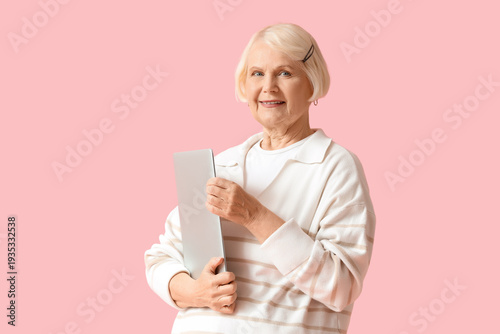 Senior woman with laptop on...