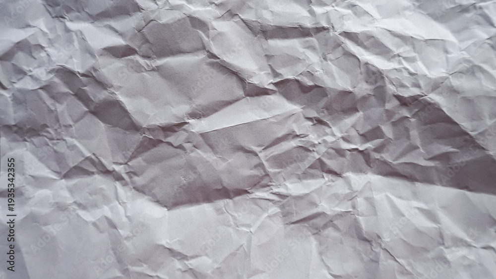 Obraz premium Crumpled white paper texture background with natural wrinkles and soft shadows, abstract messy paper surface pattern for creative design backdrop and realistic stationery material