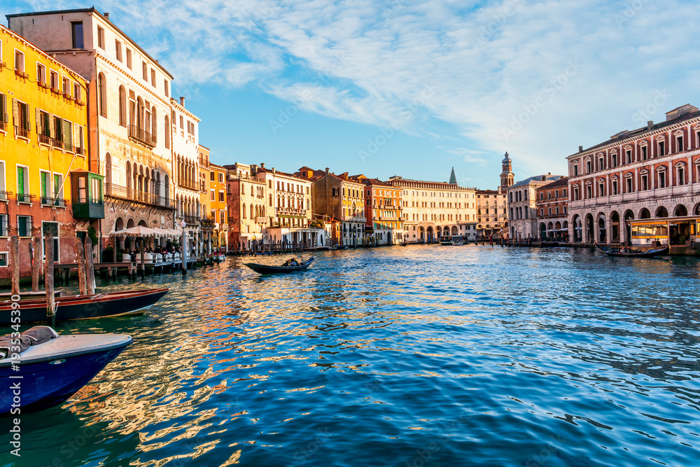 Obraz premium romantic view of a canal in Venice with boats and blue water and beautiful vintage buildings around the cityscape