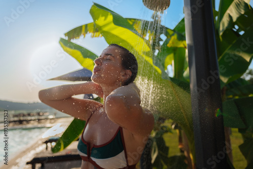 Foto Woman enjoying an outdoor shower by a pool in a tropical villa on a sunny summer