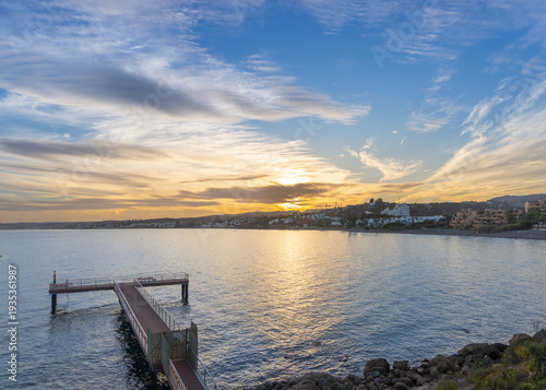 Beautiful sunset from a watchtower overlooking the sea, reflecting the sunset in the blue waters.