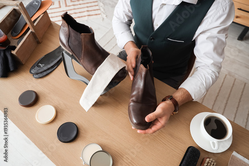 Male shoemaker polishing le...