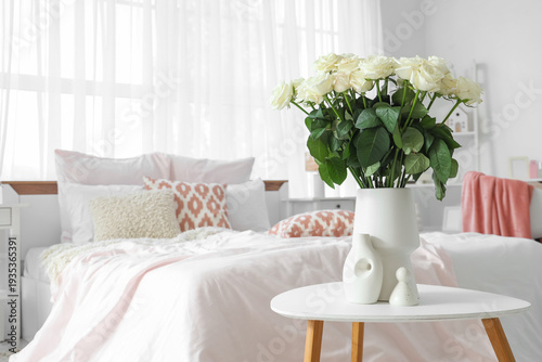 Vase with white roses on ta...