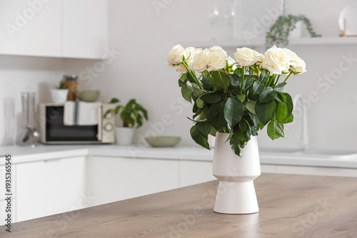 Vase with white roses on ta...