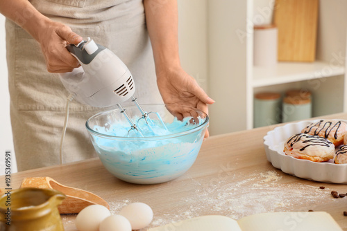 Woman whipping blue egg alb...