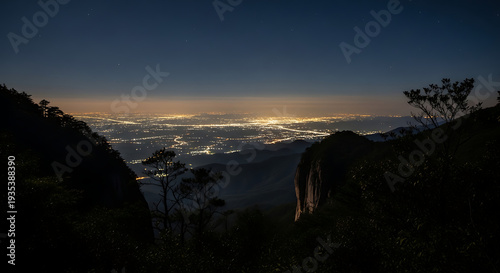 Serene mountain vista overlooking a glowing city at twilight with a clear sky