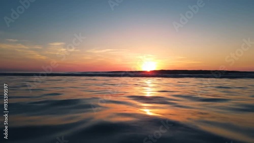 Golden sunset over ocean with peaceful waves and clear sky