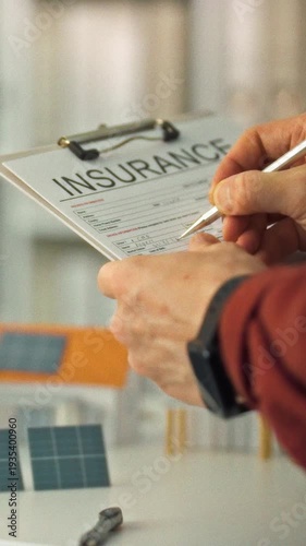 Person diligently completes renewable energy insurance application form cluttered office desk, surrounded by miniature models homes solar panels, highlighting paperwork process eco-friendly projects