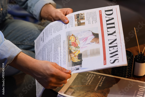 Young man reading newspaper...