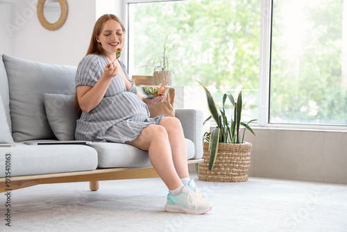 Young pregnant woman eating...