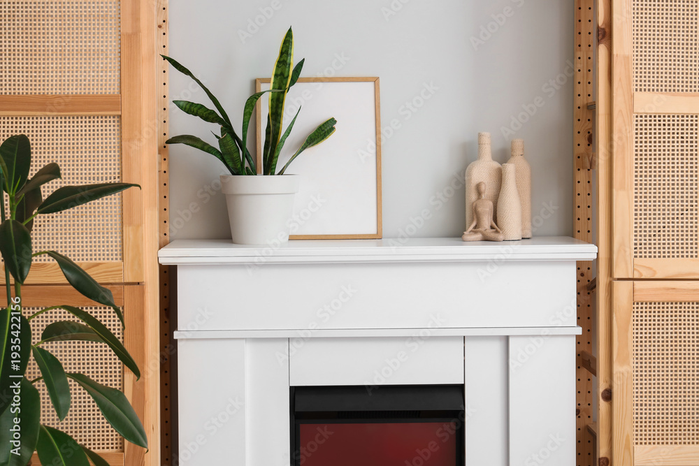 Obraz premium Plant with frame and decor on fireplace in living room