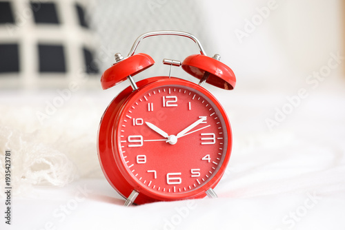 Red alarm clock on bed, clo...