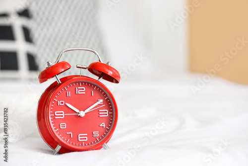 Red alarm clock on bed, clo...