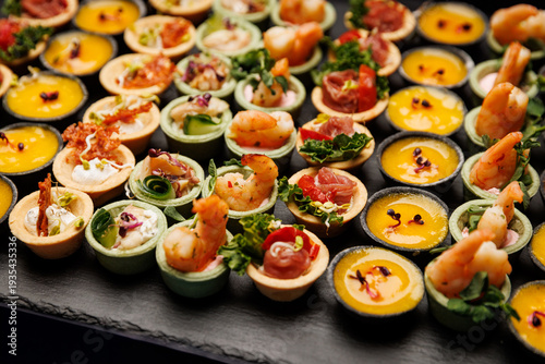 Assorted gourmet appetizers and tartlets on a slate tray