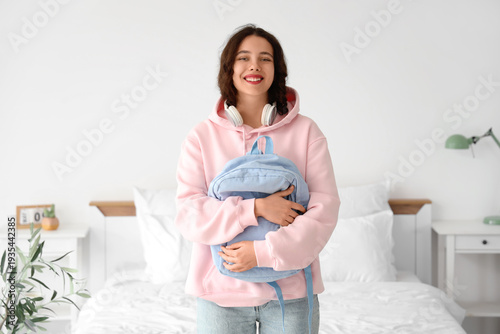 Female Indian student with backpack in bedroom