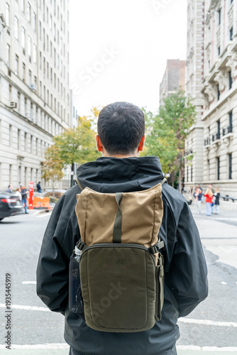 Tourist man with backpack on the street in Manhattan, New York City. Tourist man exploring the city by walking.