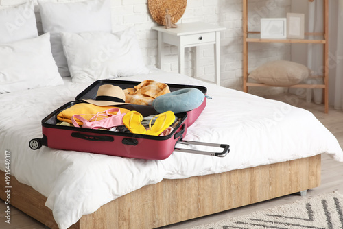 Unpacked suitcase with clot...