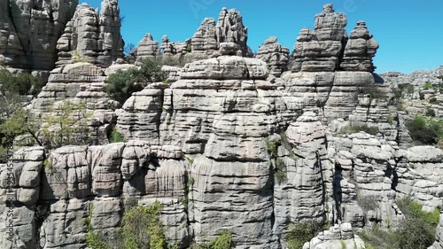 Aerial view of the unique layered limestone formations of El Torcal de Antequera, bathed in sunlight against a clear blue sky, El Torcal de Antequera, Andalucia, Spain.