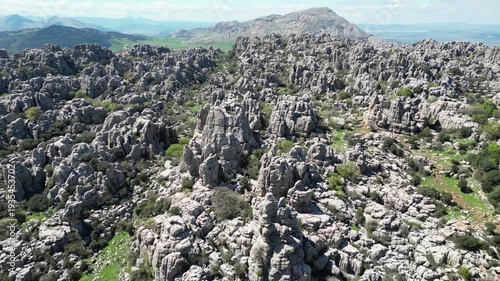 Aerial view of the rugged El Torcal de Antequera revealing stark grey rocks contrasting with the sparse green vegetation, El Torcal de Antequera, Andalucia, Spain.