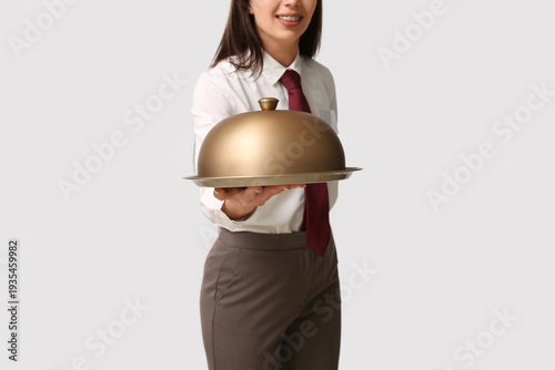 Waitress with metal tray an...