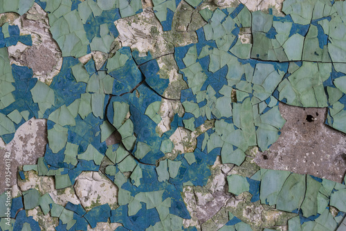 Peeling paint on the wall. Old concrete wall with cracked flaking paint. Weathered rough painted surface with patterns of cracks and peeling. Grunge texture for background and design. High resolution.