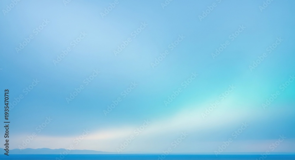 Fototapeta premium A serene blue sky with a hint of white clouds, stretching out over a vast ocean with a distant mountain range in the distance.
