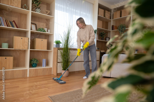 Photography Woman mopping wooden floor for home cleaning