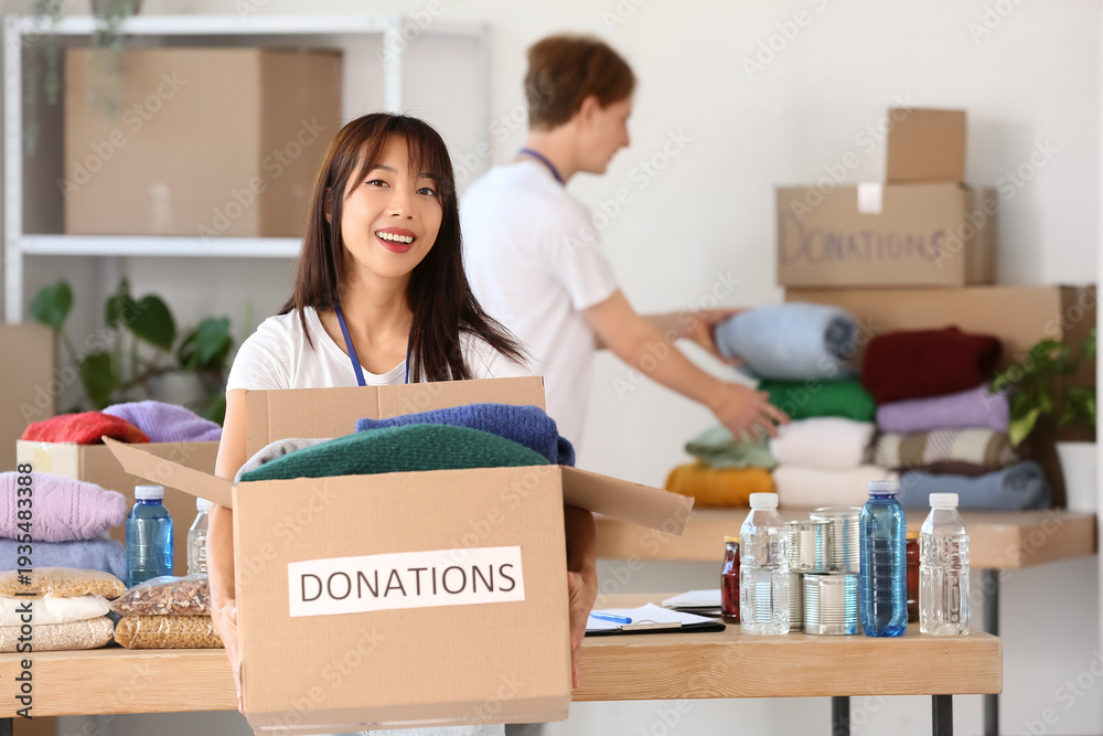 © Pixel-Shot - Young female volunteer with donations for poor people in center © Pixel-Shot - Young female volunteer with donations for poor people in center