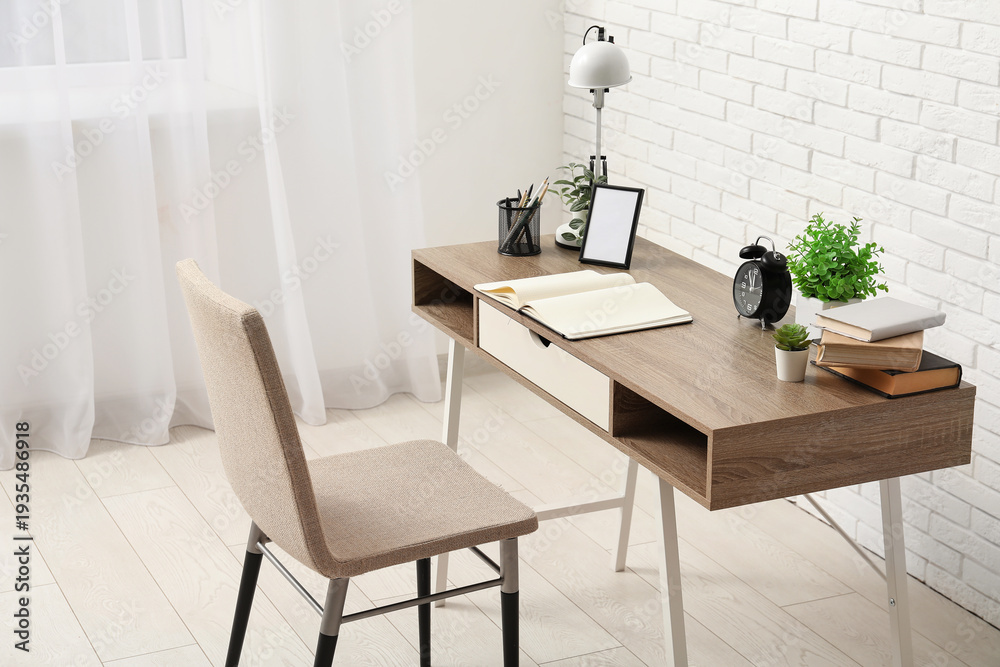 Fototapeta premium Stylish desk, lamp, notebook and chair in light room