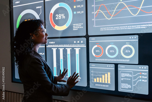 Canvas Print Professional analyzing an interactive data dashboard with charts and graphs on a large screen, reviewing metrics and trends in a modern office setting