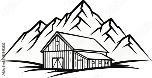 Rustic barn nestled at the base of majestic, rugged mountains