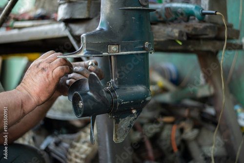 Canvastavla The hands of a master auto mechanic repair a gasoline outboard marine engine