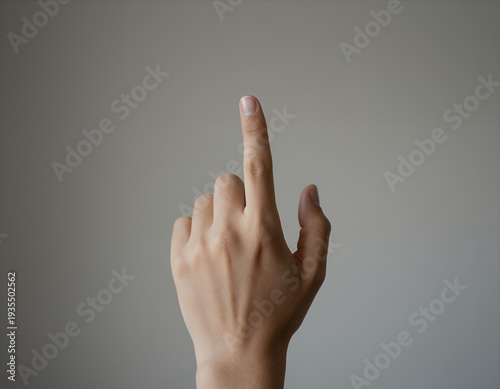 Close-up of a Human Hand with Index Finger Extended Upward Against Neutral Gray Background, Minimalist Photography for Concept Images or UI Design