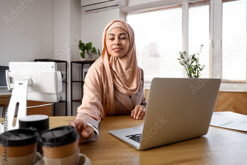 Muslim businesswoman taking...