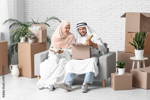 Young Muslim couple unpacki...