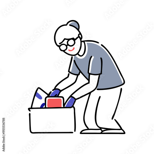 Elderly person packing belongings into a box while smiling  