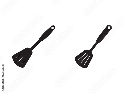 Two black silicone spatulas with handles and holes isolated on white background for kitchen use  cooking utensils