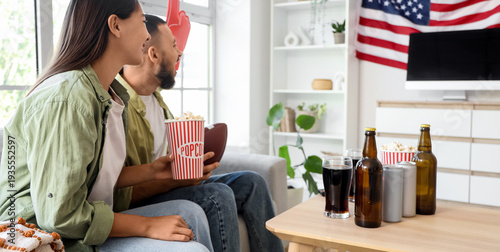 Young couple with popcorn w...