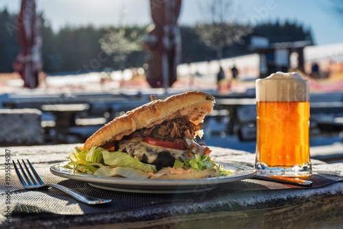 Bild auf Leinwand Cheeseburger and Beer at Outdoor Restaurant in Ski Resort
