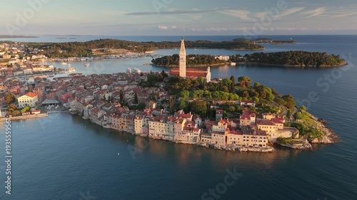 Wallpaper Mural Aerial view of Rovinj old town at sunset, the historic St Euphemia's Church stands on the hill. Beautiful coastal cityscape of Istria is surrounded by blue Adriatic water. Rovinj at sunset, Croatia Torontodigital.ca
