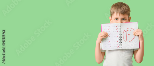 Sad boy holding notebook wi...