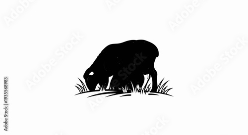 Black silhouette of a sheep grazing on grass