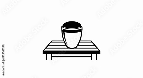 A black and white illustration of a conical cup with a domed top on a slatted platform