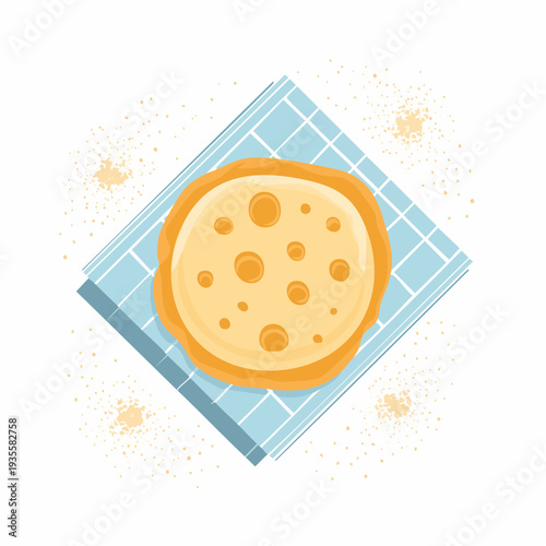 Illustrative top view of a freshly prepared warm golden pancake or tortilla on a patterned blue cloth
